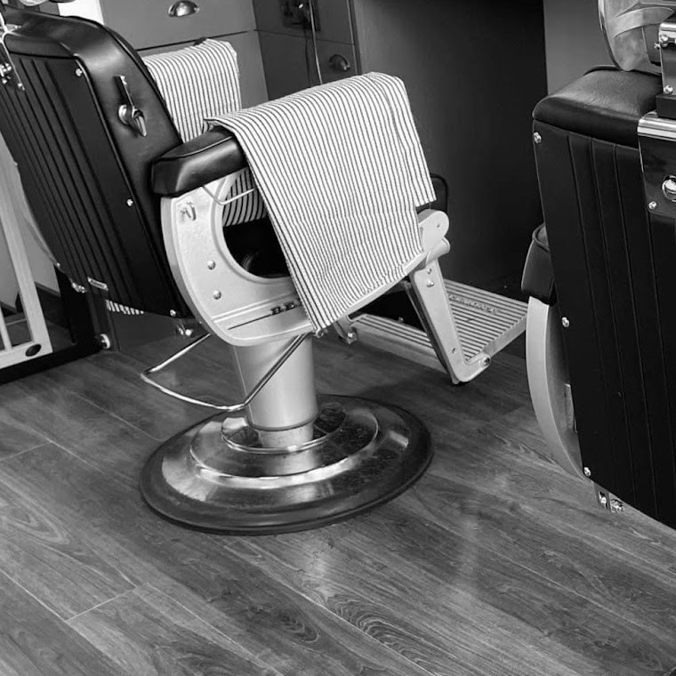 Striped barber towel draped over a vintage chair at Bernie's
